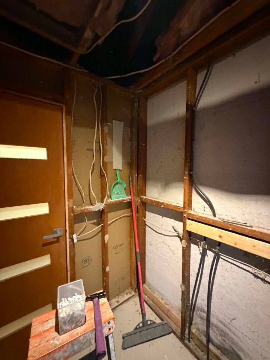 Old electrical wiring exposed in the bathroom wall frame before removal, Melton South rewire