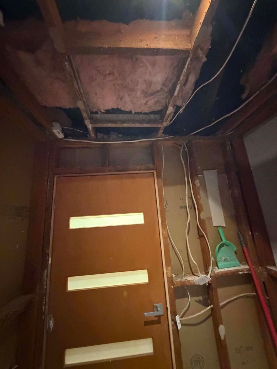 Ceiling opened above the bathroom doorway with old cabling exposed down the wall, Melton South