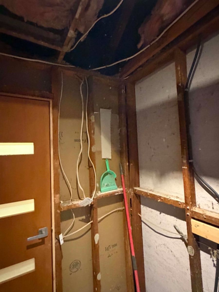 Old cabling traced from the open ceiling down the wall beside the doorway, Melton South bathroom