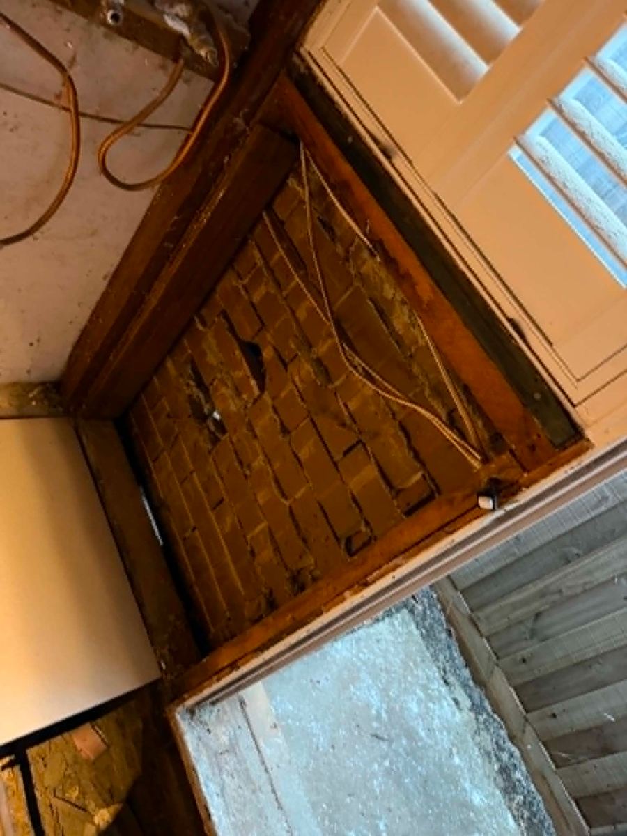 Old cabling running across exposed brick inside the opened wall, Melton South bathroom